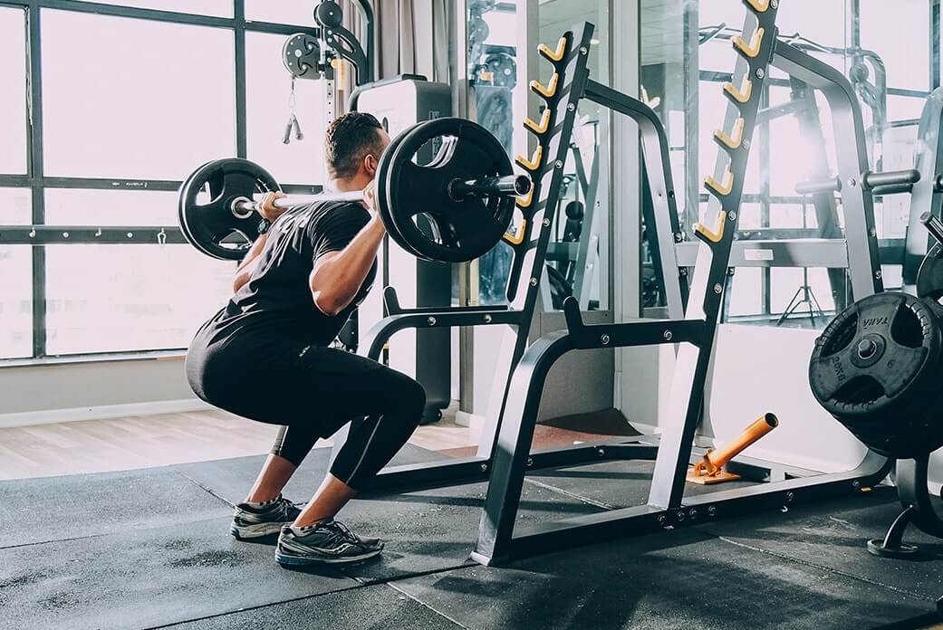Man Doing Squats at a Gym