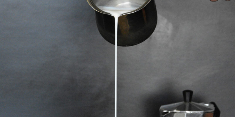 Milk Being Poured into Cup With Coffee
