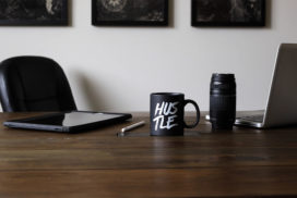 Desk with Laptop and Mug That Says Hustle