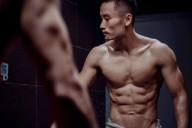 Shirtless Man Doing the Stomach Vacuum Exercise in Bathroom