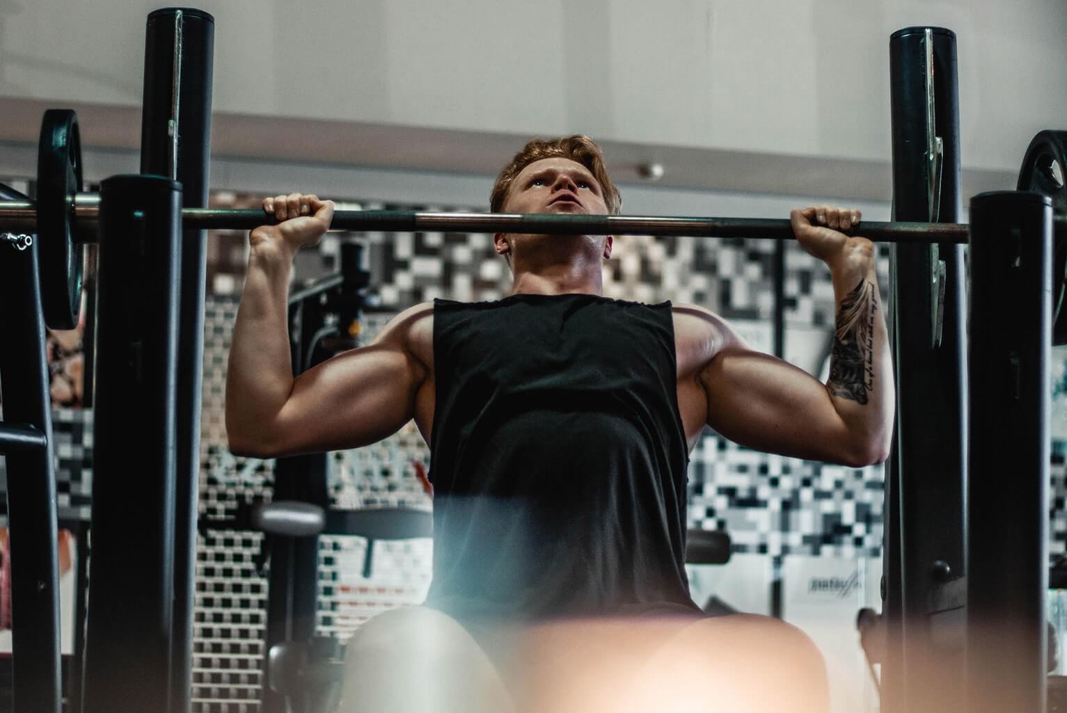 Bodybuilder Doing Barbell Shoulder Press at a Gym